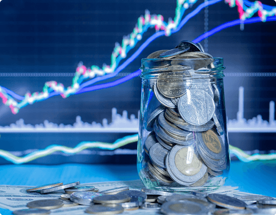 Glass jar filled with coins and financial charts